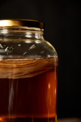 glass jar with kombucha isolated on black