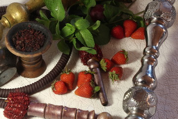 bowl with tobacco for hookah. fruits on a black background. smoking hookah