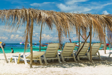 Fototapeta na wymiar Sunbeds on a paradise island, a sunny day on the beach of the resort