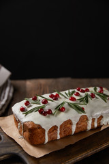traditional Christmas cake with cranberry on wooden table isolated on black
