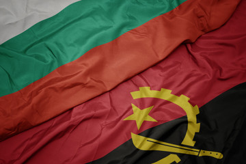 waving colorful flag of angola and national flag of bulgaria.