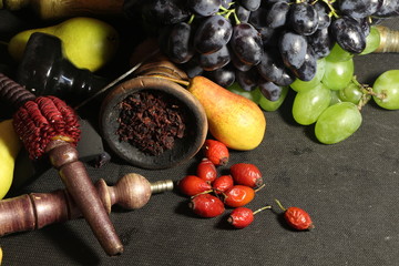 bowl with tobacco for hookah. fruits on a dark background. smoking hookah