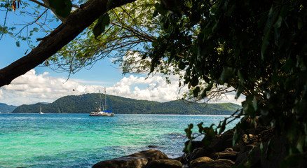 Yacht in the blue sea against the backdrop of the island