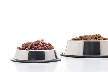 selective focus of assorted dry pet food in bowls isolated on white