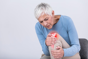 Senior woman holding the knee with pain. Old age, health problem and people concept - senior woman...
