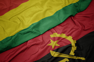 waving colorful flag of angola and national flag of bolivia.