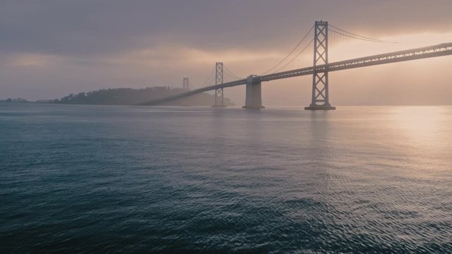 Aerial: San Francisco Bay Bridge and the embarcadero waterfront at sunrise. California, USA