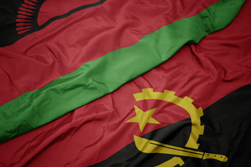 waving colorful flag of angola and national flag of malawi.