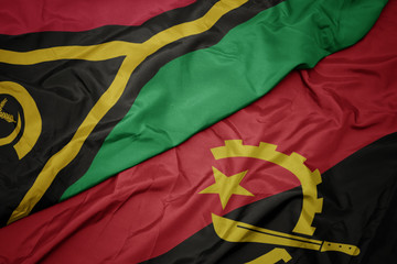 waving colorful flag of angola and national flag of Vanuatu .