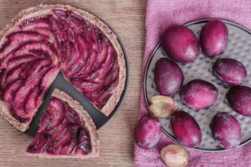 Fototapeta premium Homemade plum pie, autumn dessert with fresh plums, baking, healthy vegetarian food. Low carb dessert - plum pie with almond dough