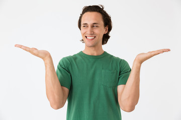Image of optimistic young man laughing and gesturing hands aside