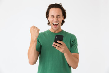 Image of happy brunette man screaming and holding smartphone