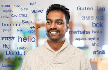 communication, translation and international concept - smiling indian man in knitted woolen sweater...
