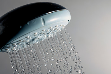 Naklejka na ściany i meble Shower head and water drops in frozen motion.