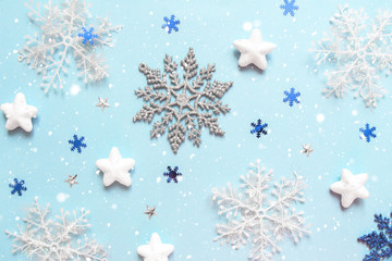 Christmas flat lay of multicolored snowflakes against blue background. Winter concept. New Year's holiday pattern