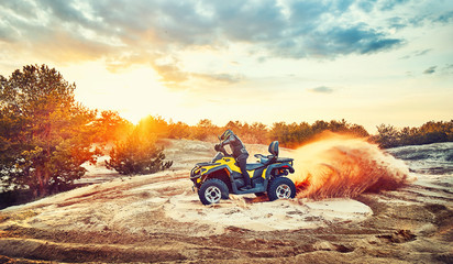 Teen riding ATV in sand dunes making a turn in the sand © 6okean