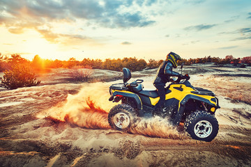 Teen riding ATV in sand dunes making a turn in the sand © 6okean