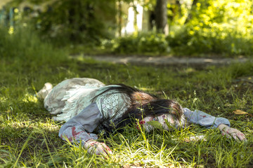 Girl zombie in the blood in the forest on the background of the house