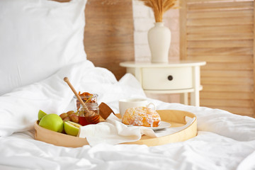 Obraz na płótnie Canvas Tray with tasty breakfast on bed