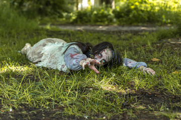 Girl zombie in the blood in the forest on the background of the house