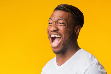 Portrait Of Afro Guy Laughing Out Loud Standing In Studio