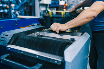 Snowboard tuning and reapair. Winter shop worker doing base repair. Rental workshop service