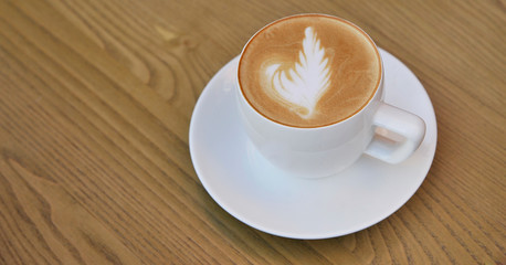 Cup of coffee on wooden background.