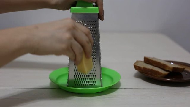 Hands grating cheese. Close-up footage.