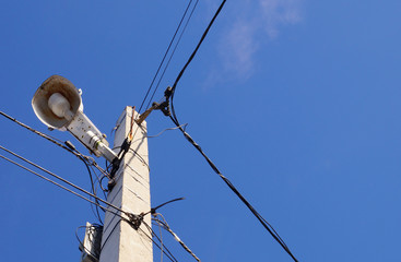  lamp and wires on an electric pole against a blue sky           