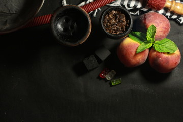 bowl with tobacco for hookah. fruits on a dark background. smoking hookah