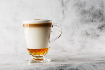 Coffee with Irish whiskey and whipped cream in glass isolated on bright marble background. Overhead view, copy space. Advertising for cafe menu. Coffee shop menu. Horizontal photo.