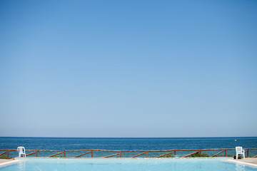 Coast line of Tunisia. In the foreground the swimming pool. In the background the azure sea and horizon. Beautiful weather, sunny day, vacation concept