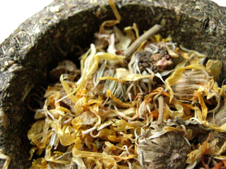 Dry grass and flower calendula in basket of pressed grass