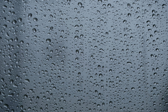 Close up selective focus raindrops outside dirty cable car window while coming down from the mountain. Bad weather, poor visibility during a hike in the Austrian Alps.