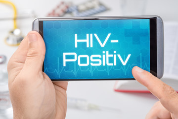 Smartphone mit dem Text HIV-Positiv auf dem Display