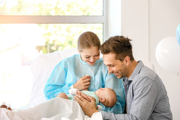 Young family with newborn baby in maternity hospital