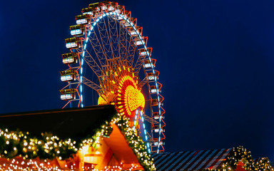 Ferris Wheel at Night Christmas Market at Town Hall Winter Berlin, Germany. German street Xmas and holiday fair in European city or town. Advent Decoration and Stalls with Crafts Items on Bazaar