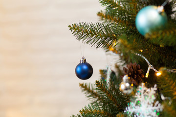 Beautiful green Christmas tree decorated with balls and garlands. Close-up photo