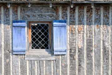 Fototapeta na wymiar Blue Shutters at Window in Log Wall
