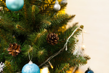 Fototapeta na wymiar Beautiful green Christmas tree decorated with balls and garlands. Close-up photo