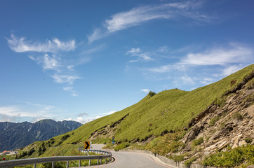 road with green grassland under blue sky