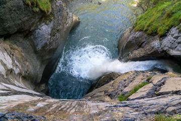 Long exposure of a hidden waterfall – waterfall in between massive rocks.