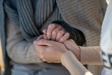 Supporting volunteer shaking hands of homeless aged woman