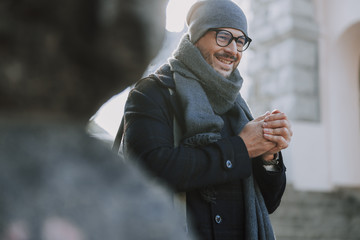 Caucasian smiling man looking for a warm cafe