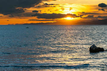 Fototapeta na wymiar Preciosa puesta de sol en la playa en barca