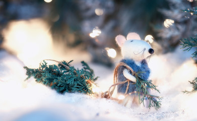 A toy white mouse a rat in a fur coat drags a Christmas tree from a forest among sparkling magic...