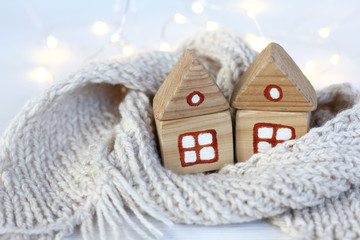 pair of wooden houses wrapped in a scarf, comfortably overwintering . Warming meeting christmas...