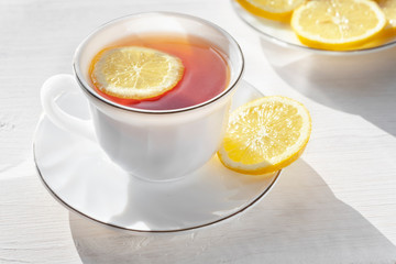 Tea with lemon. Lemon slices with tea in a white Cup.