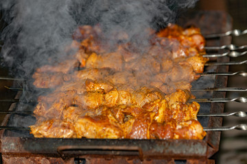 Smoke from firewood for cooking fried meat on skewers.