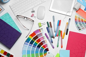 Flat lay composition with color palette and stationery on white background. Designer's workplace